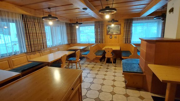 A cozy, bright room with wooden furniture and many windows. The atmosphere is inviting and rustic. - Haus Pitzwald - Sölden
