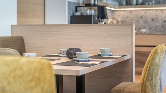 A modern dining area with a wooden table and elegant chairs. Cups and dishes are on the table, ready for a meal. - Haus Ulrich - Sölden