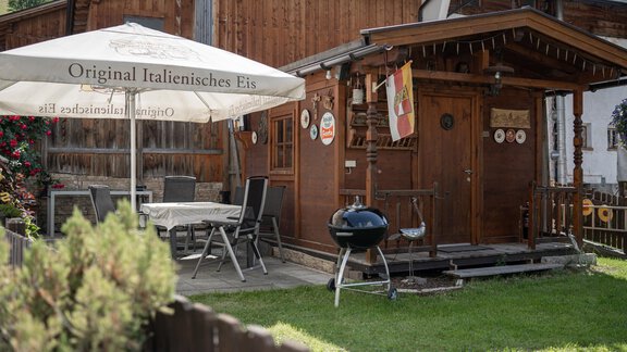 A cozy wooden stand with a sun umbrella and a grilling opportunity. The stand offers Italian ice and is surrounded by a lovely green lawn. - Haus Valtelas - Sölden