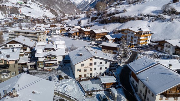 A picturesque, snow-covered mountain landscape with traditional chalets. The roofs are covered with snow, and the surroundings exude a tranquil winter atmosphere. - Haus Valtelas - Sölden