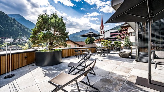 A modern terrace with loungers and a view of the mountains. The atmosphere is relaxed and inviting, perfect for unwinding in nature. - Hotel Alpina - Sölden