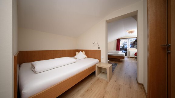 A bright room with two single beds and wooden furniture. The room is simply and modernly designed. - Hotel Garni Maria Theresia - Sölden