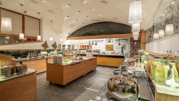 A modern buffet with various foods and drinks. The decor is bright and inviting with wood and soft lighting elements. - Hotel Liebe Sonne - Sölden