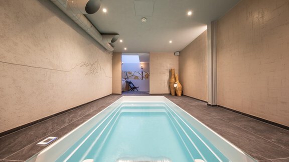 A modern indoor pool in a stylish room with neutral walls. The atmosphere is relaxing and bright, perfect for wellness. - Hotelappart Peter - Sölden
