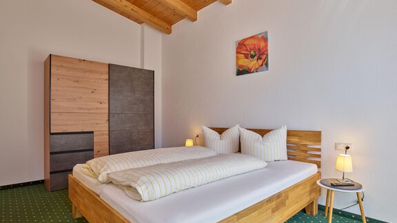 Ein gemütliches Schlafzimmer mit einem großen Doppelbett und hübschen Kissen. Der Raum hat einen Holzdecke und einen modernen Kleiderschrank. - La Luna - Sölden