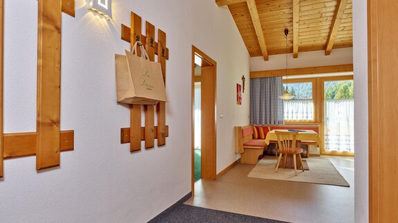 Ein helles und einladendes Foyer mit Holzdetails. Auf der linken Seite sind dekorative Elemente, und im Hintergrund ist ein gemütlicher Essbereich zu sehen. - La Luna - Sölden
