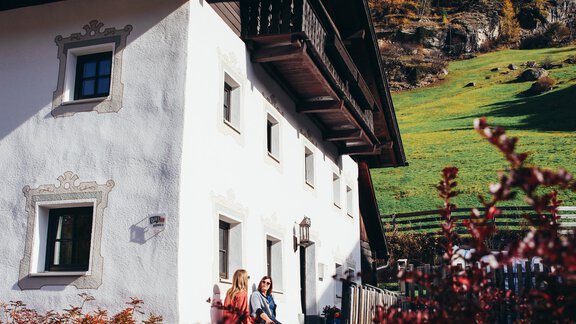 A charming house in the mountains with a lovingly designed garden. In the foreground, two women are relaxing on the terrace. - Landhaus Peater's Hoamat - Sölden