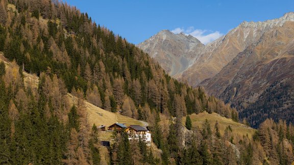 A picturesque mountain landscape with a rustic cottage. In the background, majestic mountains and forests rise. - LENI MOUNTAIN CHALET - Sölden