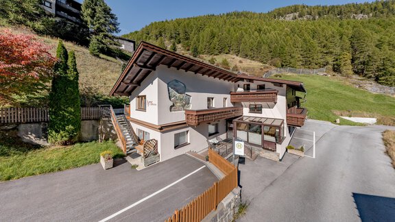 A charming house with traditional architecture amidst a green landscape. Surrounded by trees and a clear sky, it feels inviting and peaceful. - Lyns Home - Sölden