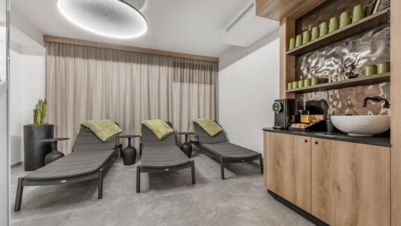 A modern relaxation area with loungers and a wooden piece of furniture. Curtains and a Nespresso machine create an inviting atmosphere. - Marco's Mountain Home - Sölden