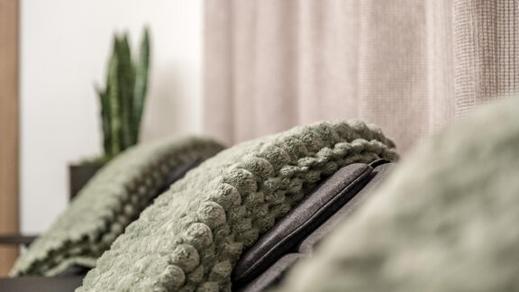 A cozy seating area with green cushions and a plant in the background. The soft lighting creates a relaxed atmosphere. - Marco's Mountain Home - Sölden