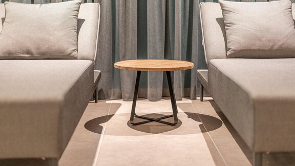 Two gray lounge chairs with cushions are positioned around a small wooden table. In the background, curtains are visible, creating a calm atmosphere. - Pension Miramonte - Sölden
