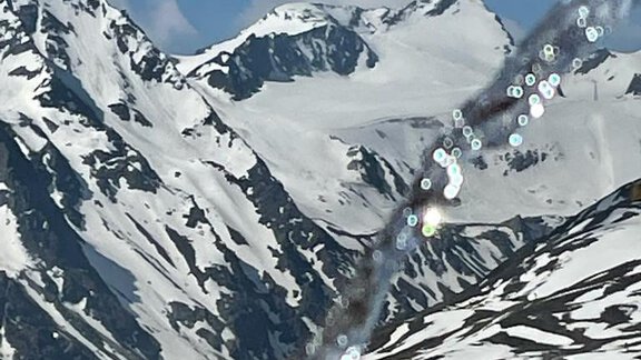 An impressive mountain landscape with snow-covered peaks under a clear sky. In the foreground, sparkling water droplets can be seen. - Top Apart Daniela - Sölden