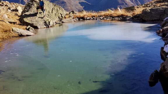 A clear, tranquil lake in a mountainous landscape. The mountains in the background are majestic and the sky shines in intense blue. - Top Apart Daniela - Sölden