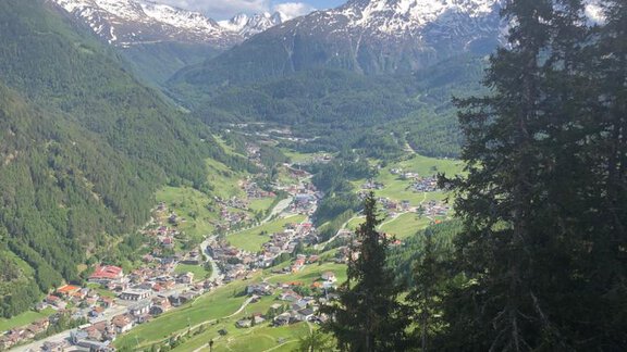 A picturesque valley surrounded by tall mountains and green forests. The small town in the valley lies peacefully among the Alps. - Top Apart Daniela - Sölden
