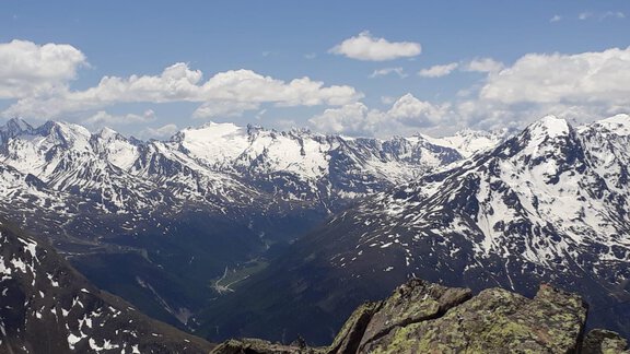 An impressive mountain landscape with snow-covered peaks and green valleys. The sky is blue with some clouds. - Top Apart Daniela - Sölden