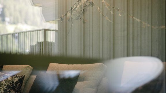 A cozy living area with beige sofas and cushions. In the background, gentle lines and natural elements are visible. - VIBES Sölden - your alpine homebase - Sölden