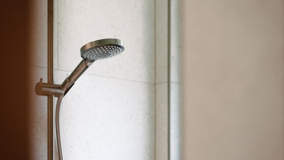 A modern shower with a hand-held showerhead and a rain shower. White tiles give the space a clean and elegant appearance. - VIBES Sölden - your alpine homebase - Sölden