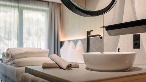 A modern bathroom with an elegant sink and a large mirror. - VIBES Sölden - your alpine homebase - Sölden