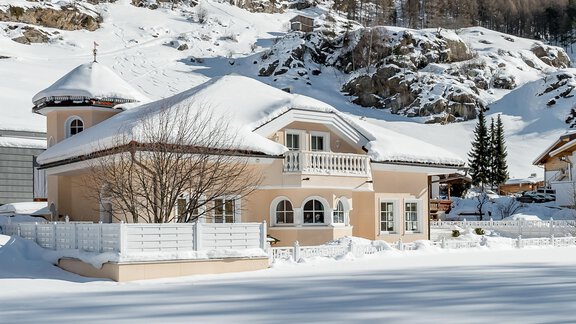 A beautiful house in the snow with a gentle hill backdrop. The surroundings are calm and wintry with plenty of white snow. - Villa Castelbell - Sölden
