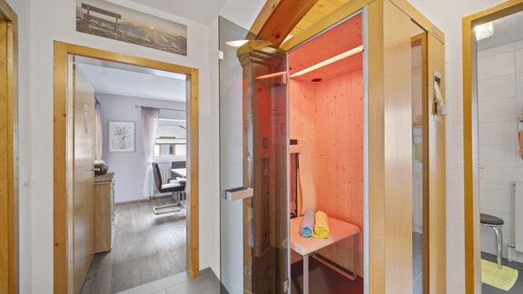 A modern room with an infrared cabin and an inviting atmosphere. The sauna is equipped with colorful towels and integrates well into the living space. - Biancas Ferienwohnung im Haus Roswitha - Umhausen