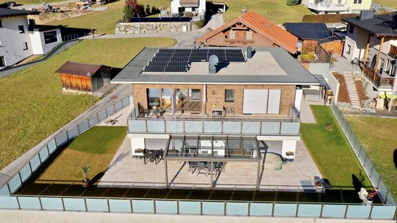 Ein modernes Haus mit Sonnenkollektoren auf dem Dach. Es verfügt über einen großzügigen Balkon und ist von einem sauberen Garten umgeben. - BLANKA'S Apart Auszeit - Umhausen