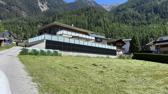 A modern house in a mountainous landscape. Green meadows and high mountains in the background create a peaceful atmosphere. - BLANKA'S Apart Auszeit - Umhausen