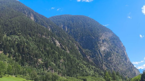 A beautiful view of high mountains and lush green meadows. The clear blue sky complements the picturesque landscape. - Ferienwohnung Martha - Umhausen