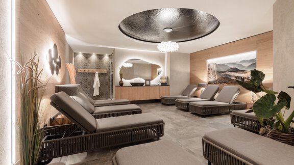 Ein luxuriöser Spa-Bereich mit bequemen Liegen und sanftem Licht. Die Wände sind modern gestaltet und es gibt Pflanzen für eine entspannende Atmosphäre. - MYALPS Ötztal - Umhausen