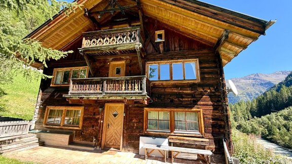 A traditional wooden house in the mountains, surrounded by trees and green grass. The blue sky creates an idyllic atmosphere. - Haus Freistabl - Vent