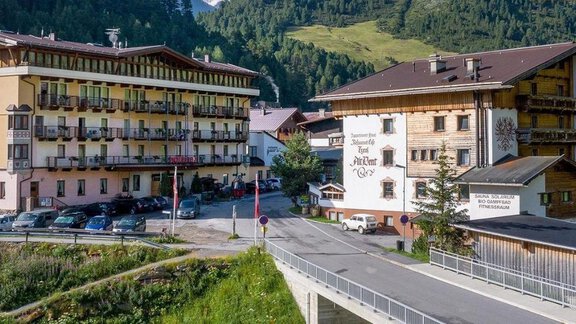 Two hotels in a picturesque mountain landscape. Green hills and a quiet road surround the buildings. - Hotel Vent - Vent