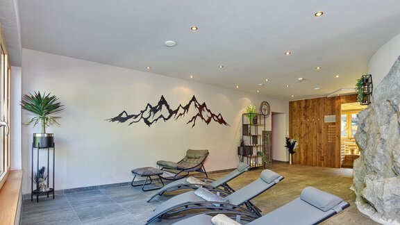 A tranquil wellness area with loungers and soothing mountain wall design. The space features large windows and a natural atmosphere. - Hotel Vent - Vent