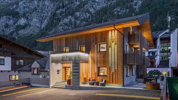A modern wooden building in the mountains that serves as accommodation. The facade is well lit and features an inviting entrance. - Garni Ötztal ROOMS & APARTS - Zwieselstein