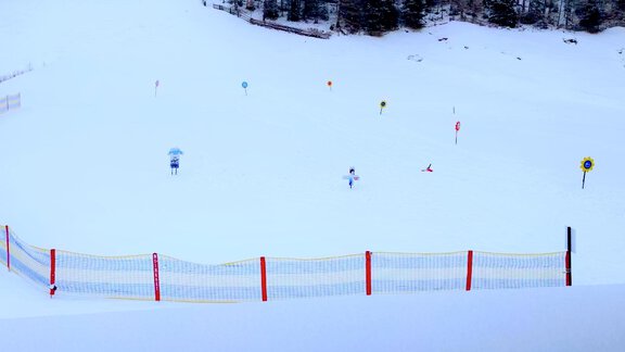 A snow-covered ski slope with various flags and barriers. Trees are visible in the background. - Haus Fortuna - Zwieselstein