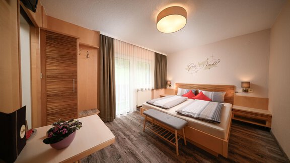 A modern bedroom with two beds and pleasant lighting.  
Large windows provide plenty of daylight and a warm atmosphere. - Haus Sonnschein - Zwieselstein