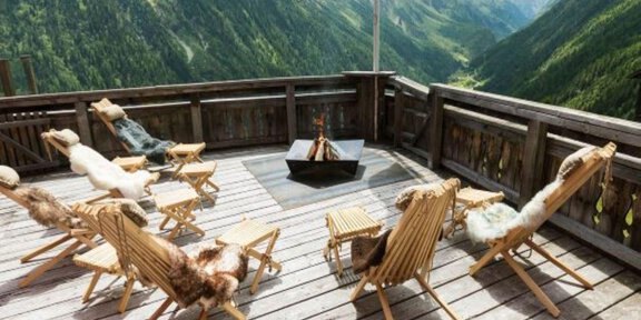 Ein gemütlicher Balkon mit Liegestühlen und einem Feuerplatz. Die Aussicht zeigt beeindruckende Berge und grüne Täler. - Hotel Silbertal - Sölden