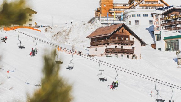 A beautiful ski resort with snowy slopes and ski lifts. In the background, cozy wooden houses and modern buildings can be seen. - Haus Maria - Hochsölden | © manuel jammer