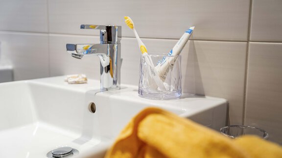A modern bathroom with two sinks and large mirrors. The space is bright and designed in a minimalist style, with a shower and towels. - Berghof Reich - Längenfeld