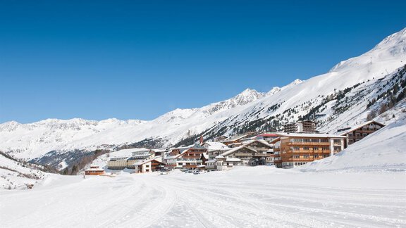A snowy mountain landscape with a small village. The sky is clear and blue, and the mountains are majestic in the background. - Haus Alpenblick - Obergurgl  | © Haus Alpenblick, Fam. Scheiber