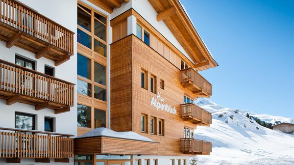 A modern hotel with wood and glass design in a snowy mountain area. The sunny facade and balconies offer a beautiful view of nature. - Haus Alpenblick - Obergurgl  | © Haus Alpenblick, Fam. Scheiber