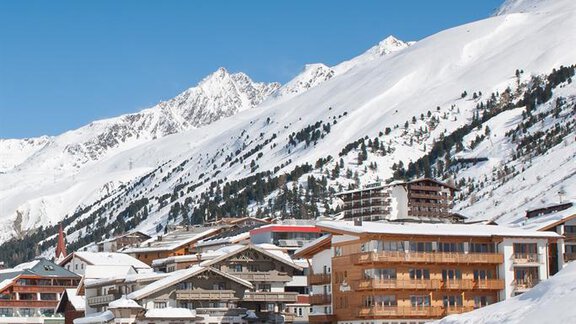 A picturesque mountain village in the snow with modern and traditional buildings. The clear blue sky and the snow-covered mountains create a tranquil winter landscape. - Haus Alpenblick - Obergurgl  | © Haus Alpenblick, Fam. Scheiber