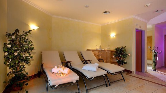 A relaxing wellness area with loungers and soft lighting. Plants give the room a calming ambiance. - Haus Martinshof - Obergurgl 