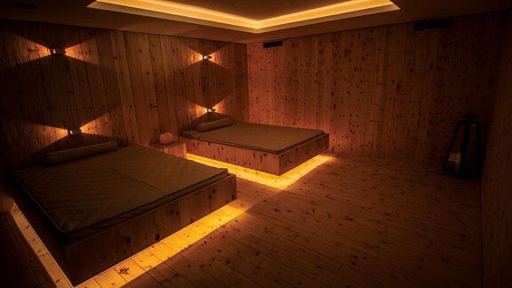A stylish room with two beds and warm, indirect lighting. The walls are made of wood, creating a cozy atmosphere. - Schönblick Gurgl - Obergurgl 