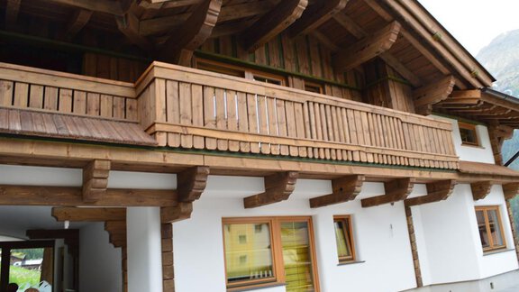 A traditional wooden house with a spacious balcony. The facade is in light tones and creates an inviting impression. - Am Trogwohl - Sölden
