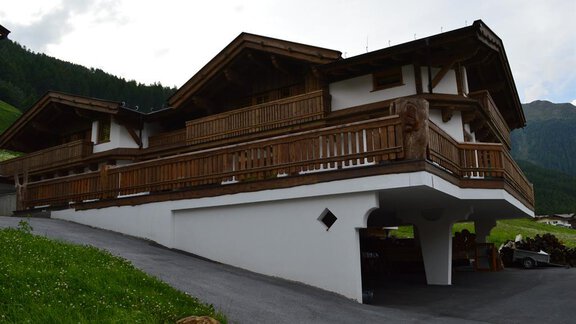 A modern house with wooden cladding and several balconies. It is situated in a green, mountainous area. - Am Trogwohl - Sölden