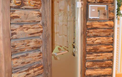 A rustic wooden door with a modern glass section. The walls are clad in untreated wood, creating a cozy atmosphere. - Am Trogwohl - Sölden