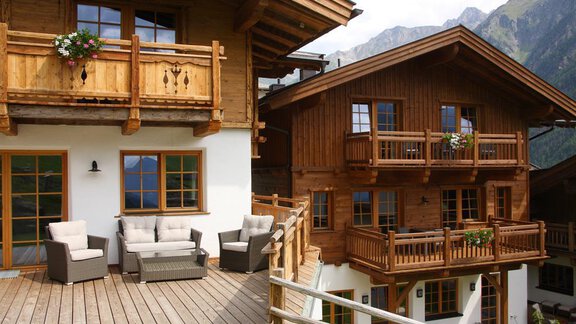 Ein gemütliches Holzhaus mit Balkonen und Terrassen. Der Blick auf die Berge im Hintergrund sorgt für eine wunderschöne alpine Atmosphäre. - Andis Almdorf - Sölden