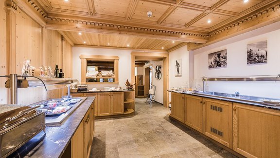 A modern kitchen with wooden surfaces and elegant details. The room is well-lit and offers plenty of space for cooking. - Andre Arnold - Boutique Hotel - Sölden
