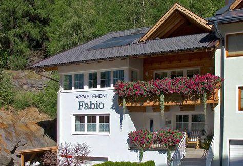A modern apartment building named "Fabio" with blooming balcony plants. Surrounded by lush greenery and a tranquil atmosphere. - Appartement  Fabio - Sölden
