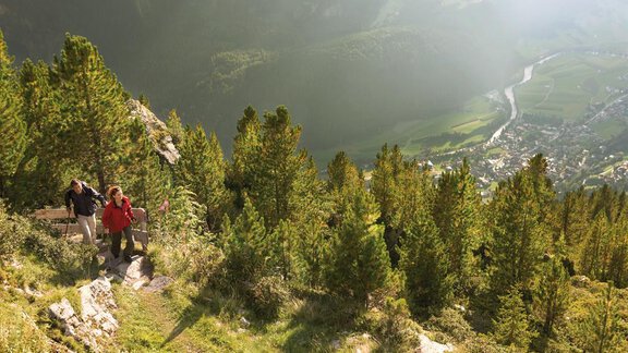 Two hikers are climbing a path in the mountains. In the background, a valley with green meadows and a river can be seen. - Appartement  Fabio - Sölden